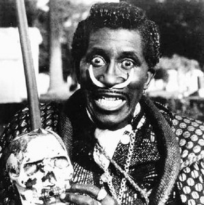 Studio publicity portrait of Screamin' Jay Hawkins holding a skull-topped staff.