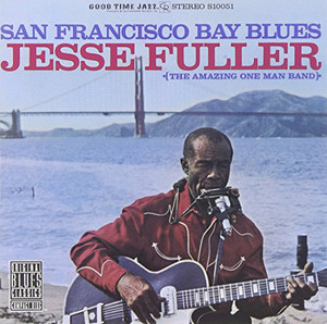 Jesse Fuller plays guitar outdoors with the Golden Gate Bridge in the background.