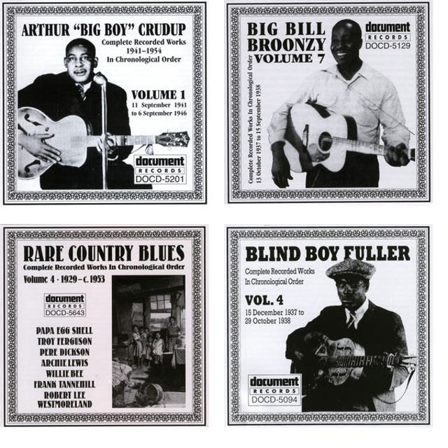 Bob Koester holding cake in a crowded group photo at a Delmark celebration.